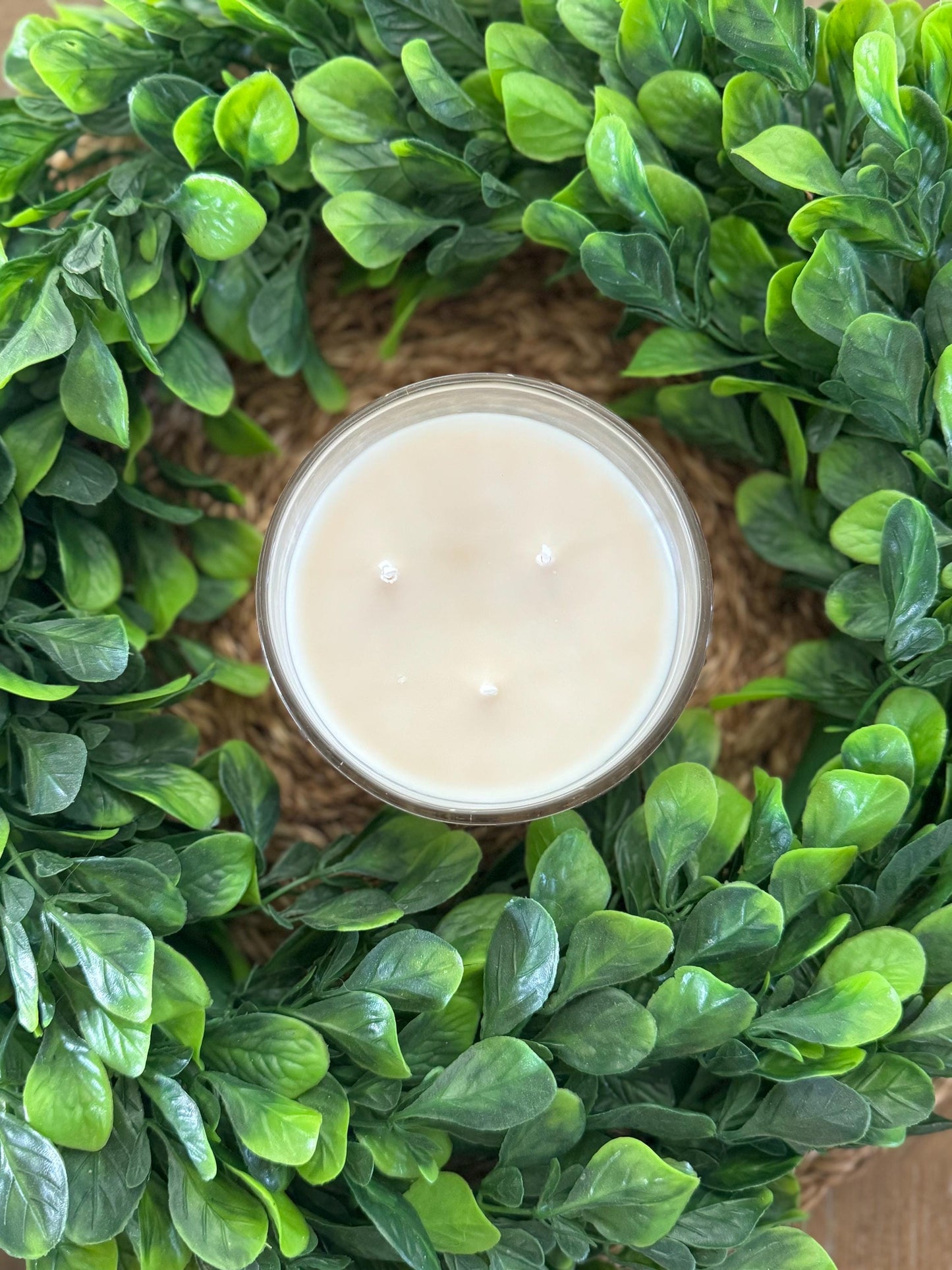 a candle is sitting in a wreath on a table