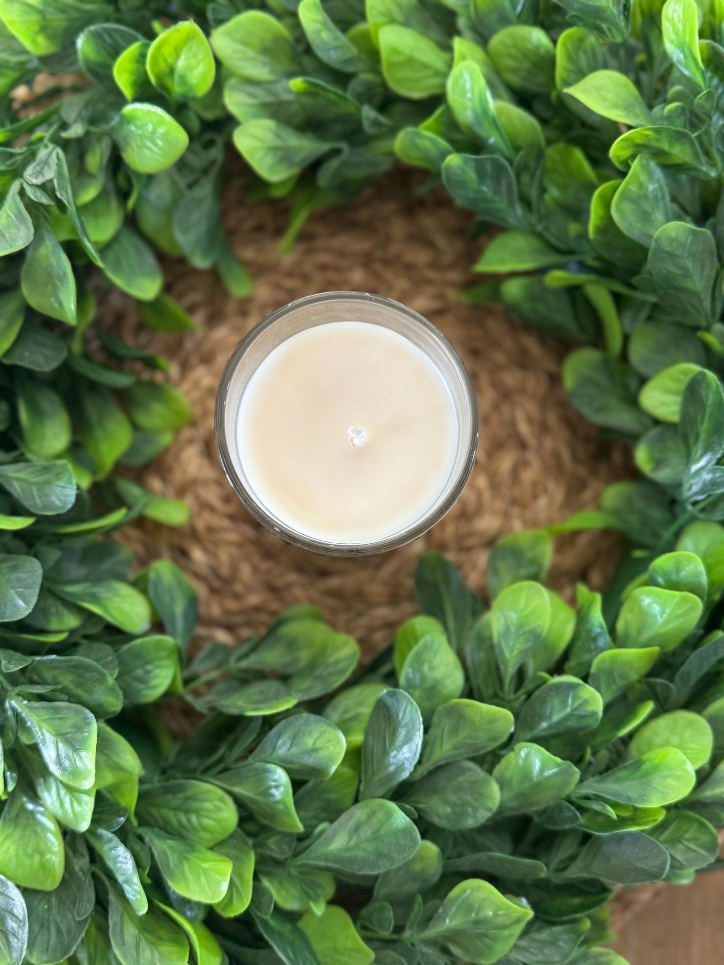a candle sitting on top of a lush green wreath