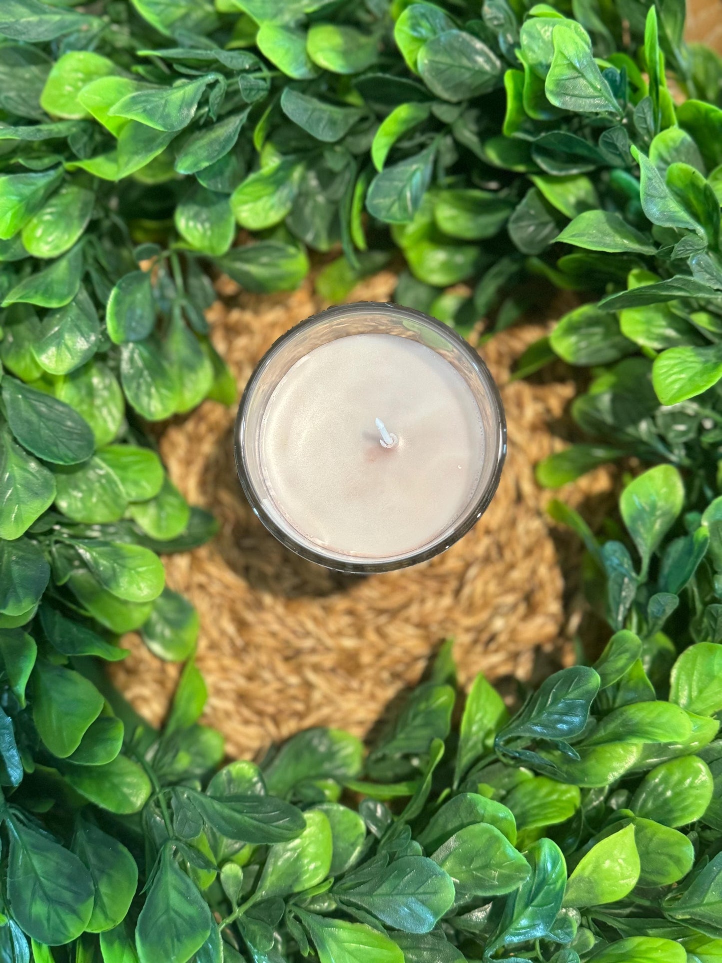 a candle sitting on top of a lush green plant