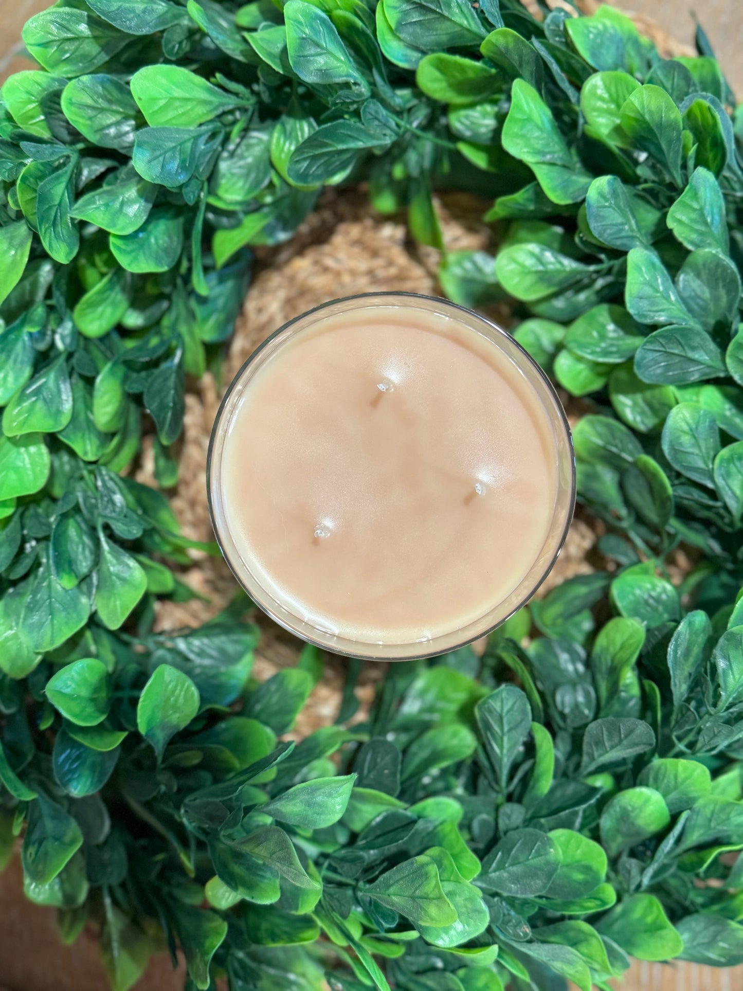 a candle sitting on top of a green wreath