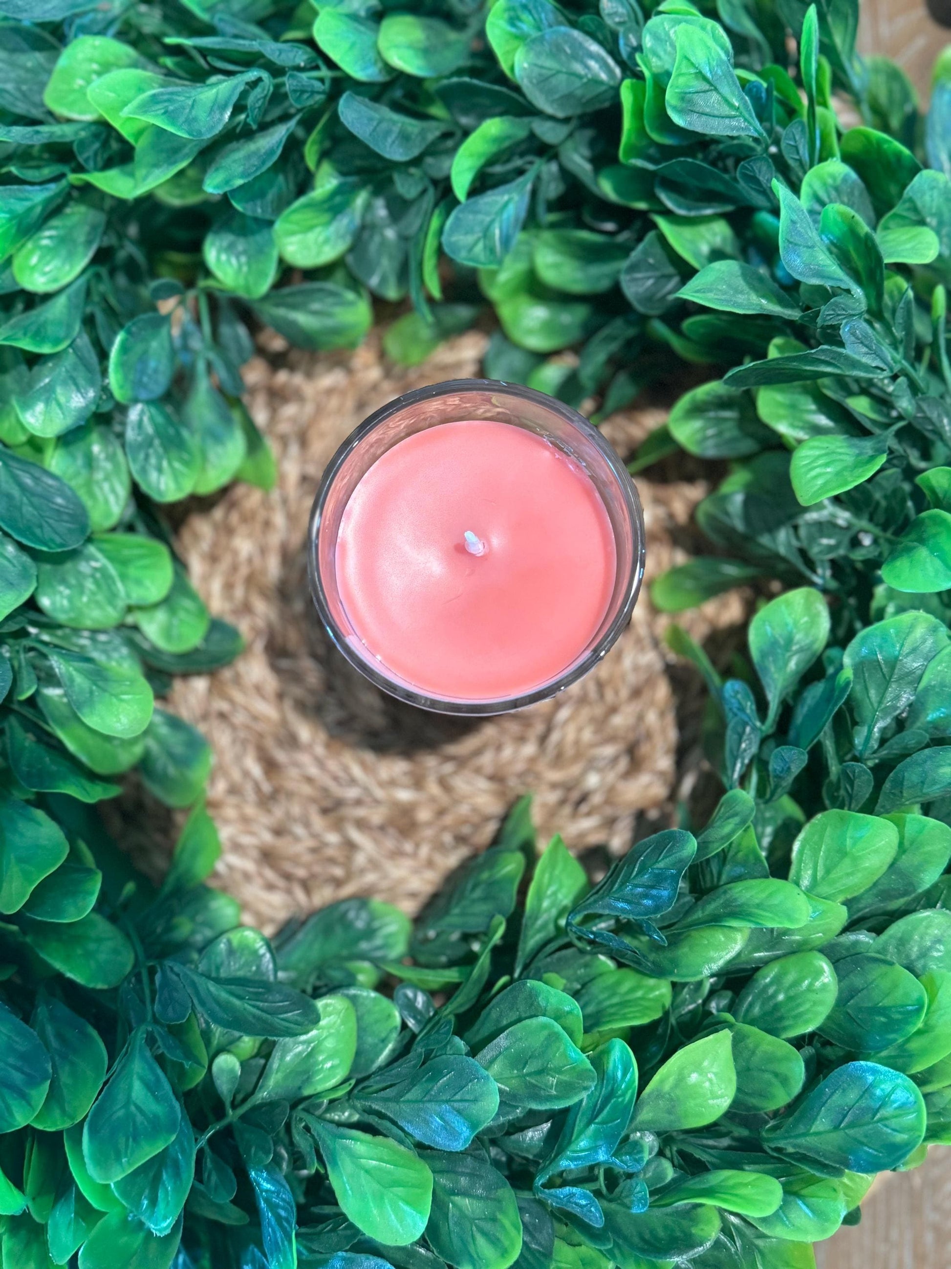 a red candle sitting on top of a green wreath
