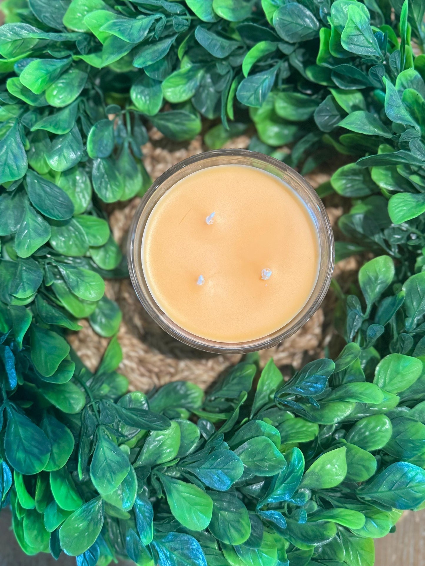 a candle sitting on top of a green wreath
