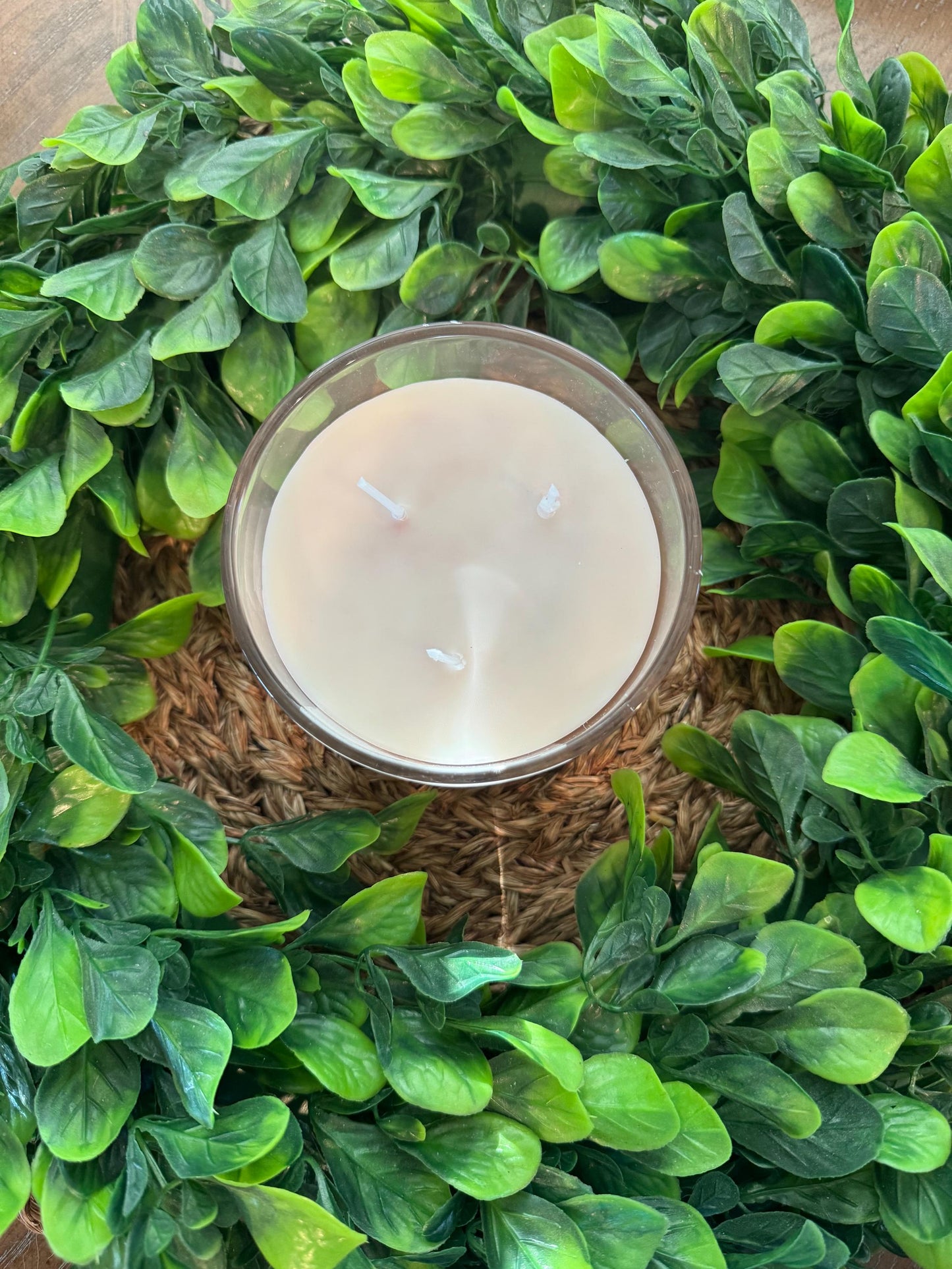 a candle surrounded by green leaves