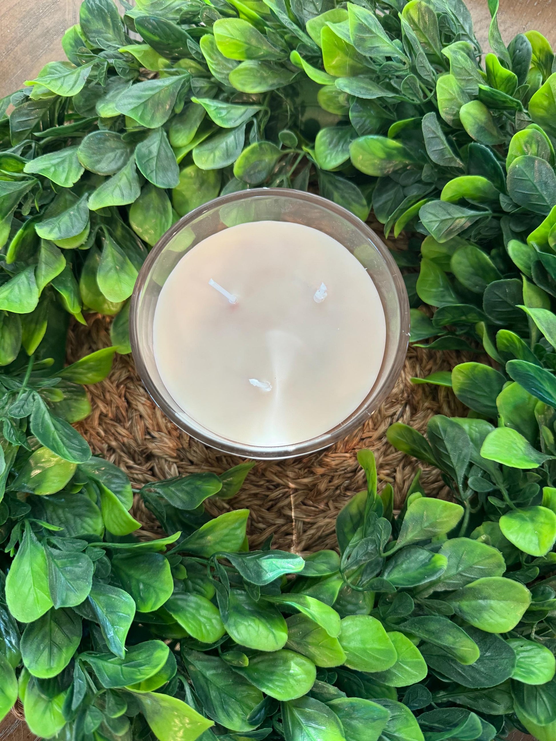 a candle surrounded by green leaves