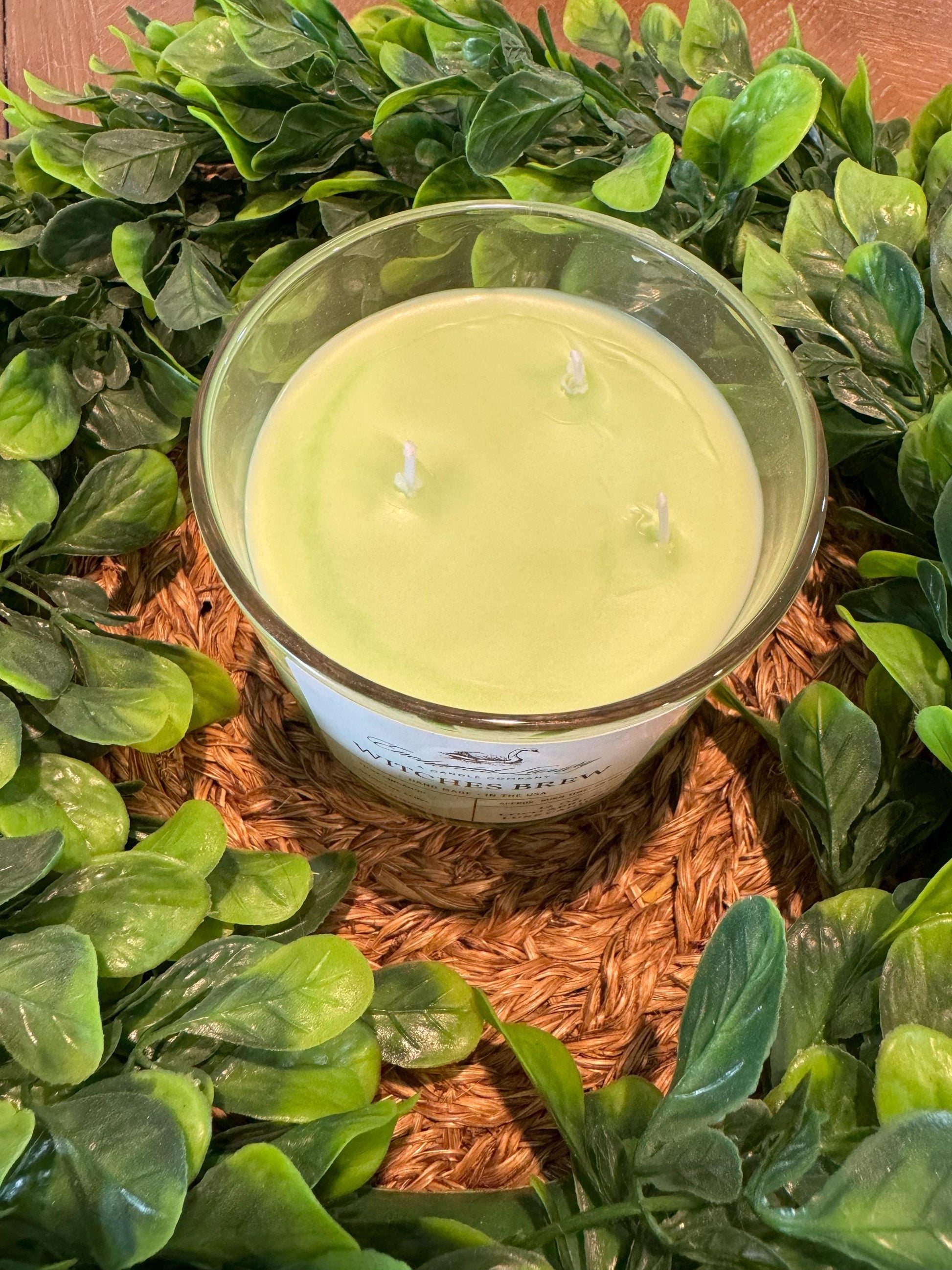 a candle surrounded by green leaves