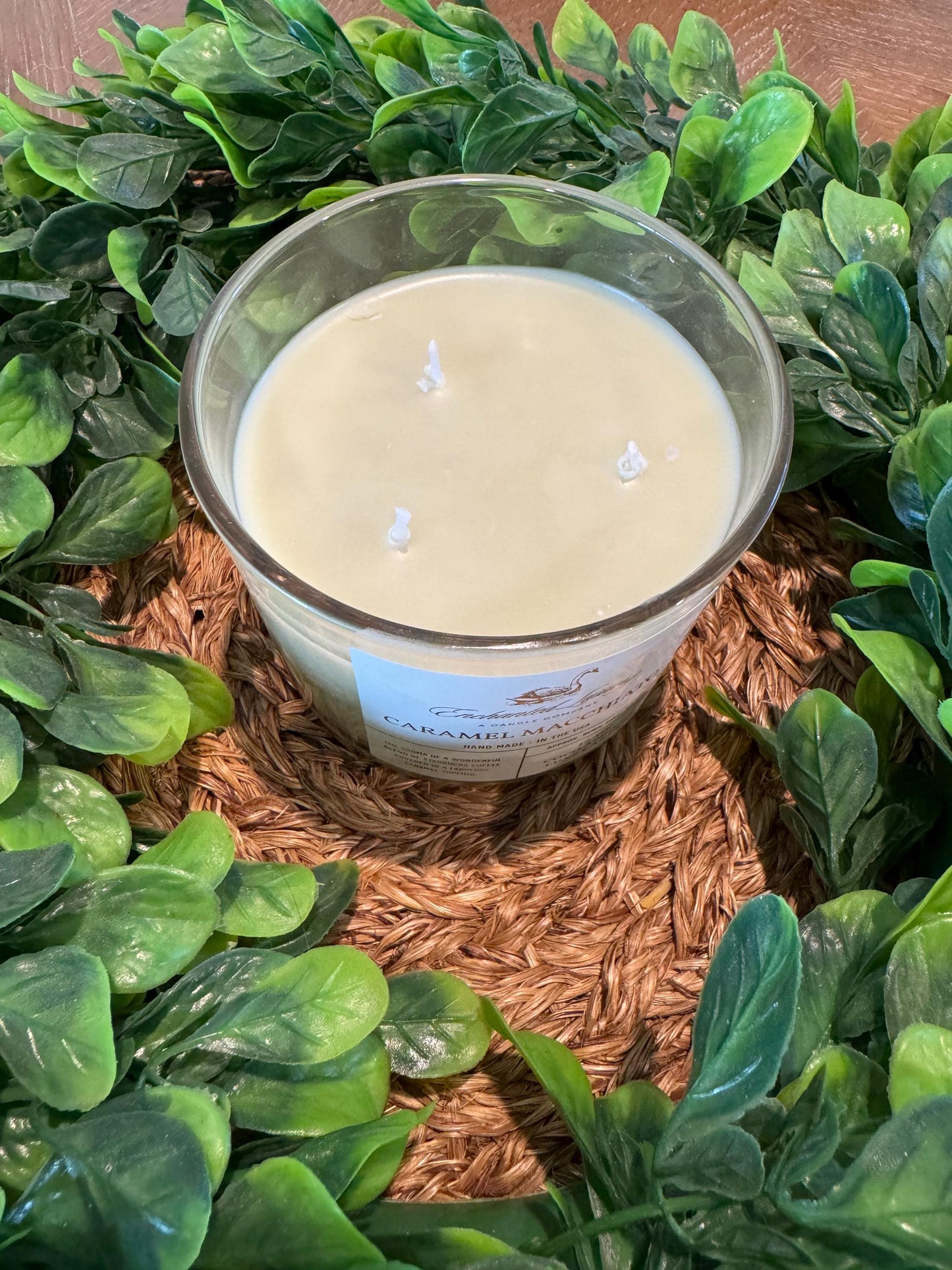 a candle surrounded by green leaves
