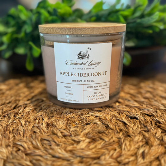 a candle of apple cider donut sitting on a table