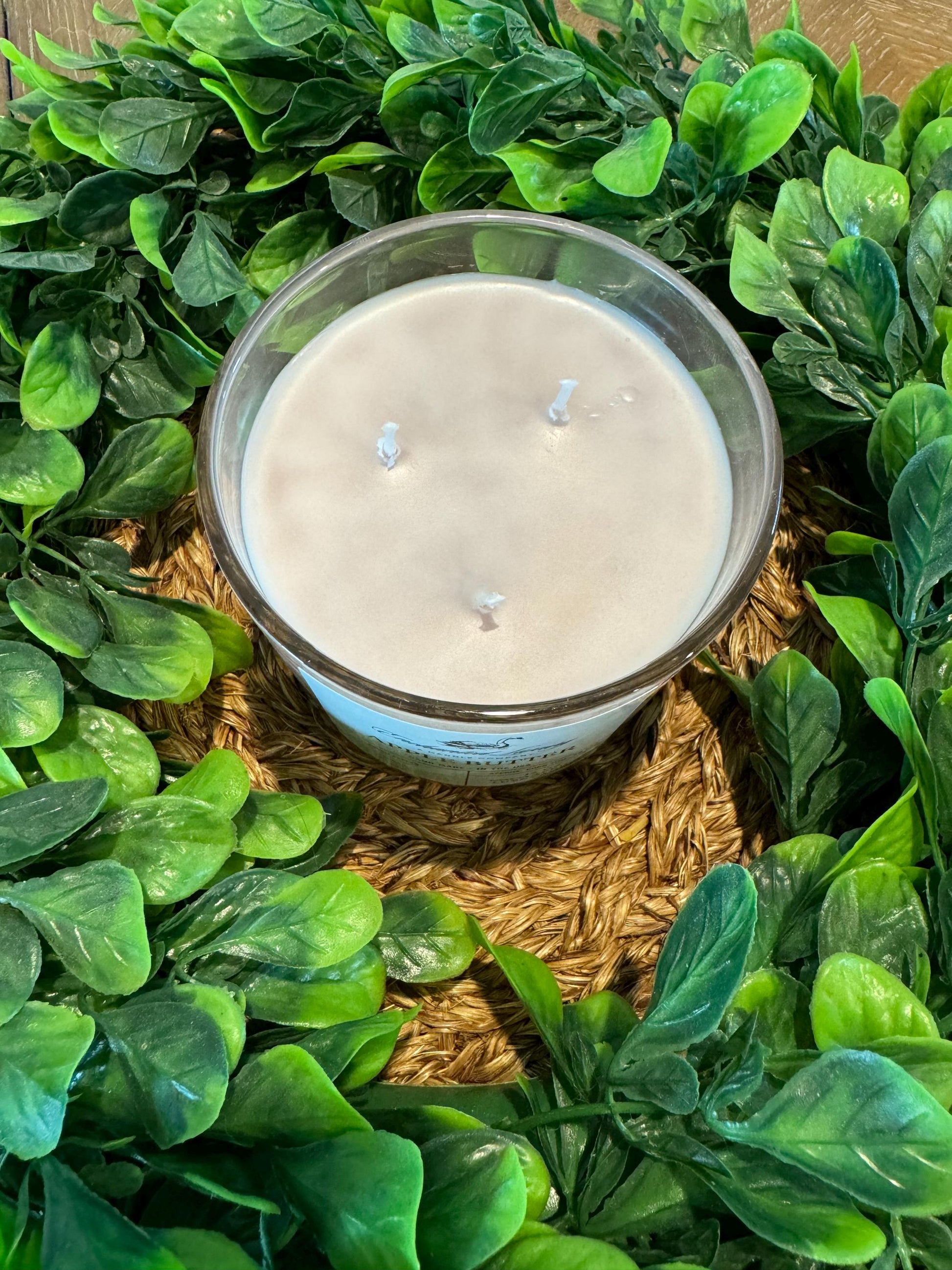 a candle surrounded by green leaves